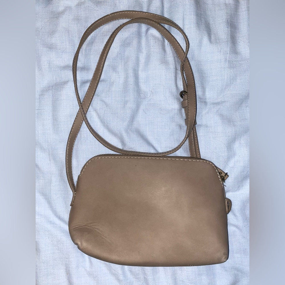 Small tan colored crossbody purse.